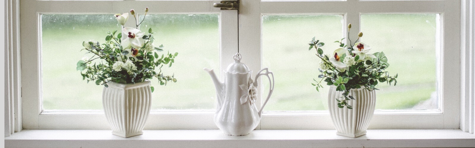 Two vases with flowers in a window sill